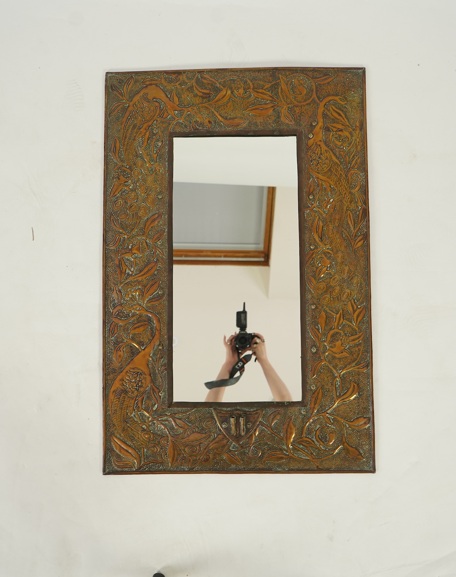 An Arts and Crafts embossed copper mirror, manner of Talwin Morris, Glasgow School